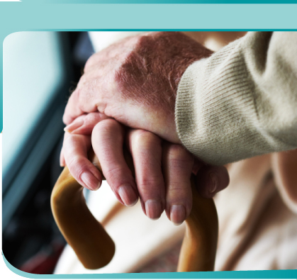 Old woman’s hand on a wooden cane with an old man’s hand resting on top of it.